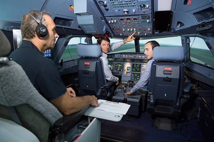 Pilots in a cockpit simulator, one holding paper notes, the workaround the design watched and learned from