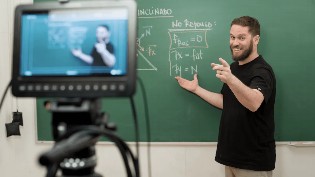 A Descomplica teacher filming a lesson at the blackboard, the classroom content reshaped for voice